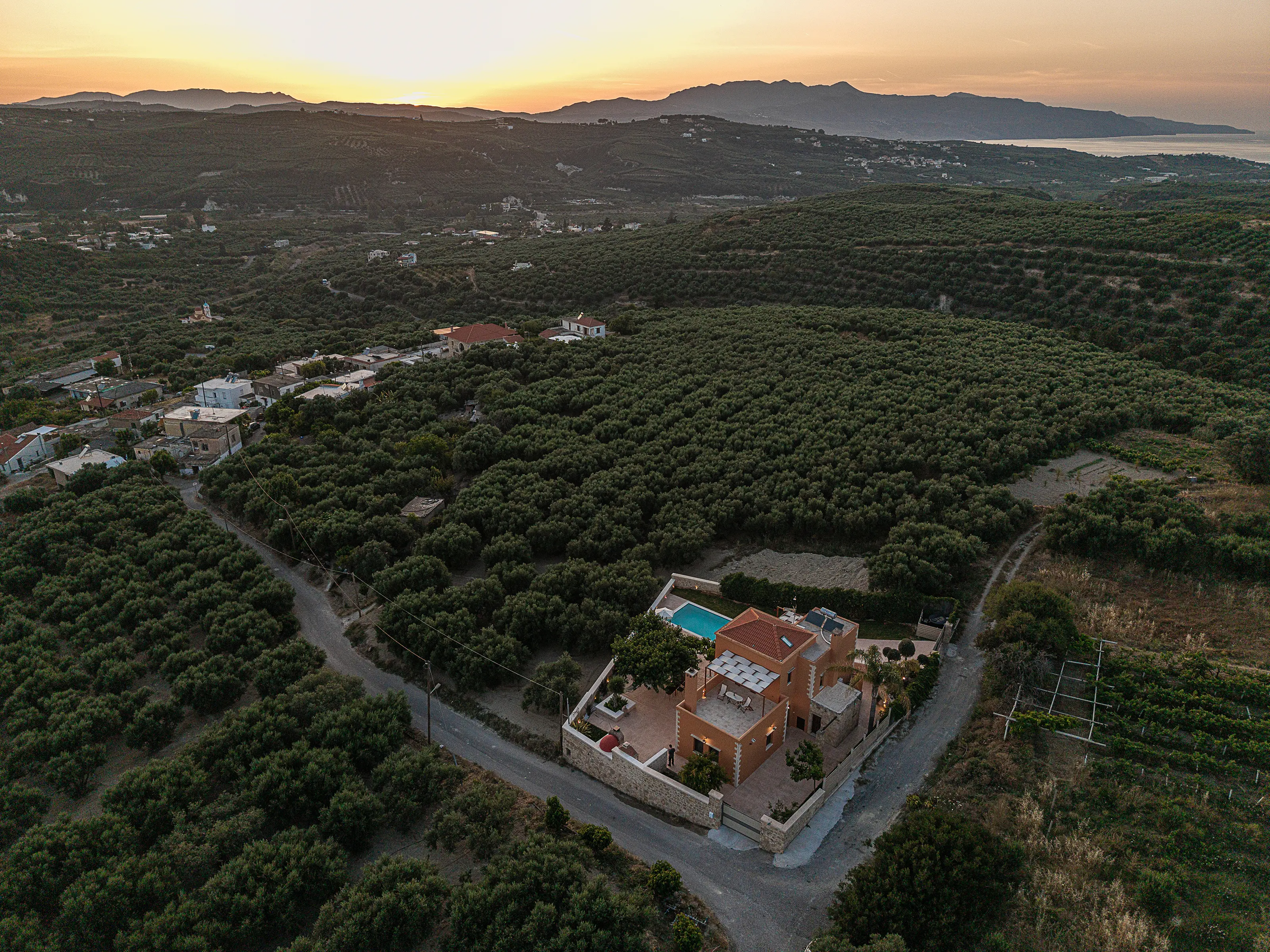Sunset over the White Mountains and the coast: the village of Elliniko on the left, olive groves, the house small at the bottom right